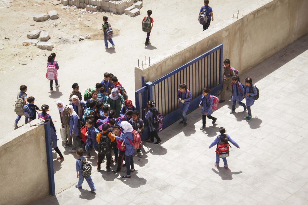 It’s very busy at the gates at this time: Syrians are entering the school  to line up at the schoolyard to begin their class after the welcoming ritual. The Jordanians exit the building through the main and side entrance. At the gates carpooling Jordanian parents are waiting to pick up their children at the end of their school day.